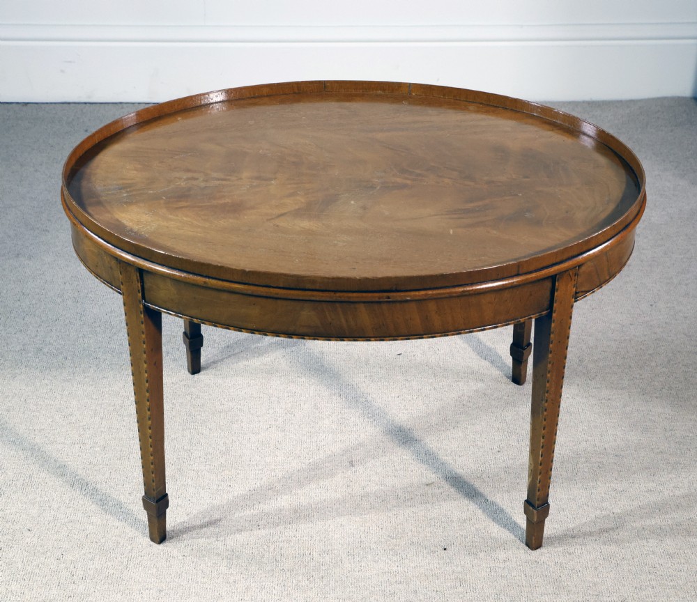 An oval mahogany low table featuring a raised gallery tray top, line inlay along the apron, and four square tapered legs. View III