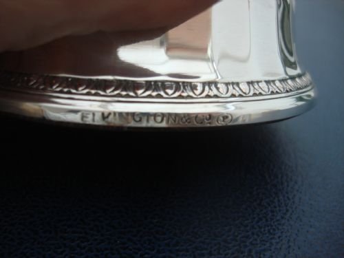 fig 2. A small circular silver-plated mirror plateau featuring fluted side panels and egg-and-dart decorative borders around the top and base.