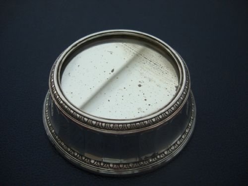 fig 1. A small circular silver-plated mirror plateau featuring fluted side panels and egg-and-dart decorative borders around the top and base.