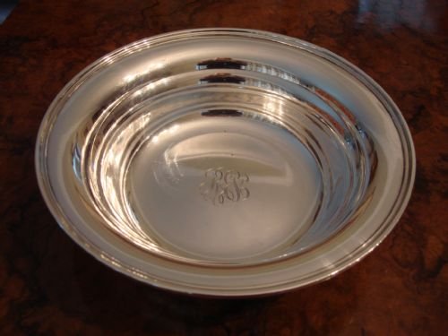 fig 1. A circular solid silver bowl featuring a stepped rim and an engraved monogram in the centre.