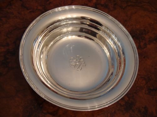 fig 2. A circular solid silver bowl featuring a stepped rim and an engraved monogram in the centre.