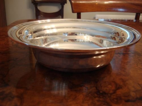 fig 3. A circular solid silver bowl featuring a stepped rim and an engraved monogram in the centre.