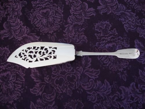 fig 1. A Victorian sterling silver pierced fish slice featuring scrollwork engraving on the blade and a fiddle pattern handle with an engraved monogram.