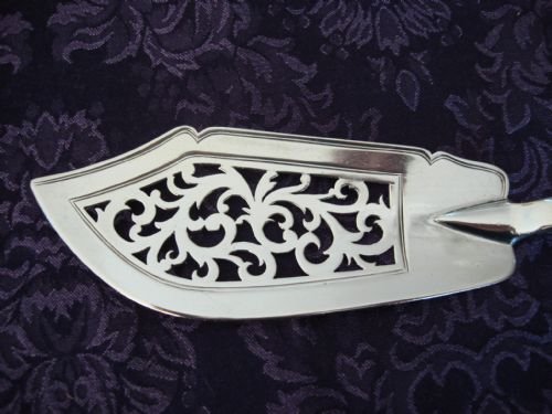 fig 2. A Victorian sterling silver pierced fish slice featuring scrollwork engraving on the blade and a fiddle pattern handle with an engraved monogram.