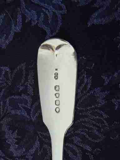 fig 4. A Victorian sterling silver pierced fish slice featuring scrollwork engraving on the blade and a fiddle pattern handle with an engraved monogram.