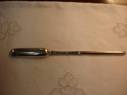 fig 1. A George II solid silver marrow scoop featuring two elongated, narrow bowls of differing widths connected by a slender central shaft.