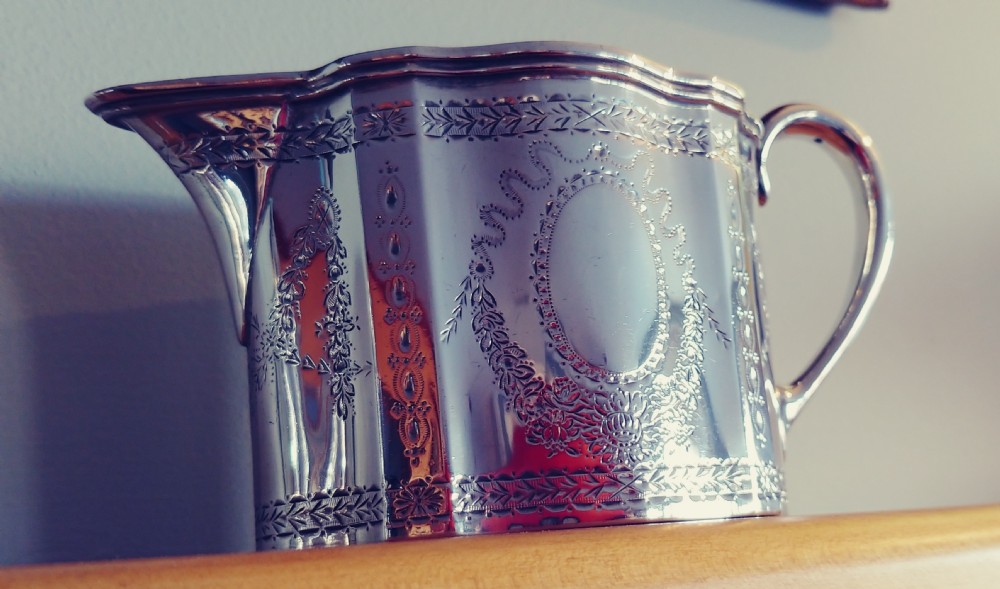 A Victorian sterling silver cream jug and matching double-handled sugar bowl featuring engraved garland motifs and curved handles. View III