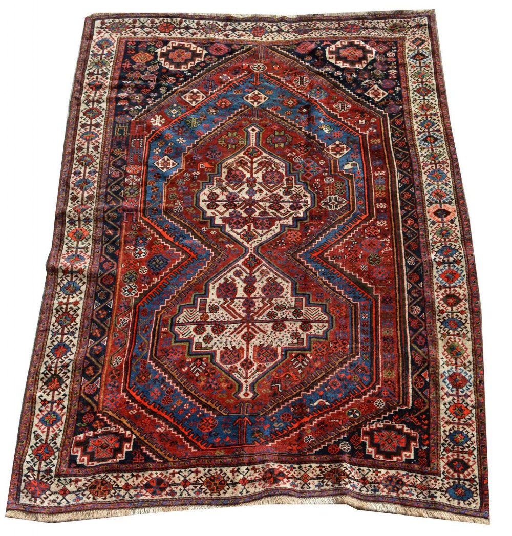 A hand-knotted Persian Afshar wool rug featuring a central geometric medallion flanked by stepped borders in shades of red, navy blue, and cream.