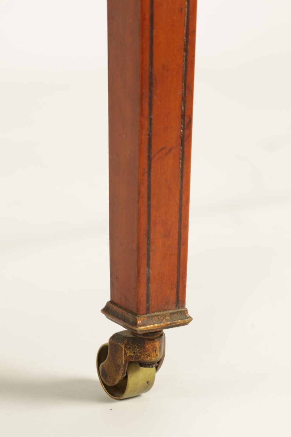 A nineteenth-century figured satinwood Sutherland table featuring two drop flaps, slatted upright legs, splayed feet, and small brass castors. View VI