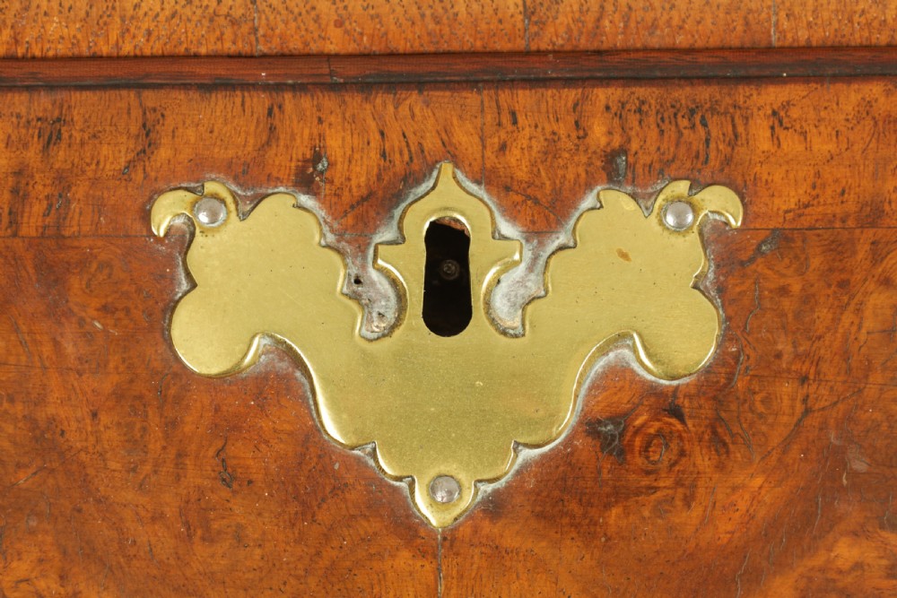 An 18th-century burr walnut bureau featuring a slant-front flap above four graduated drawers with brass handles, resting on bracket feet. View II