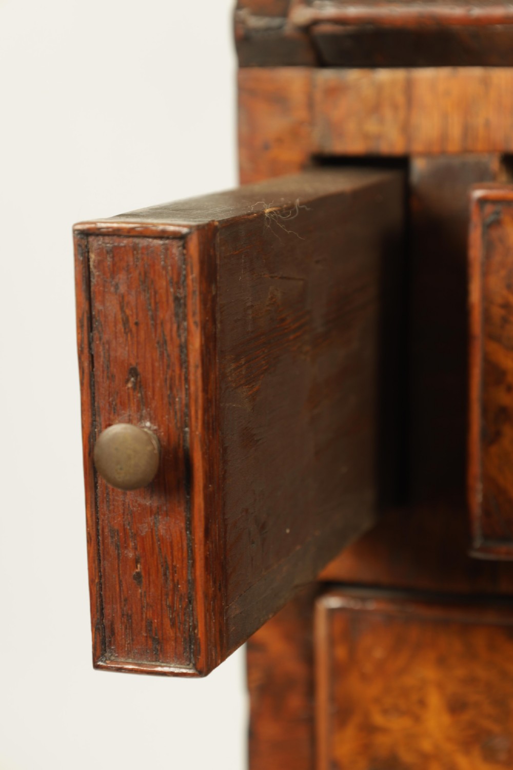 An 18th-century burr walnut bureau featuring a slant-front flap above four graduated drawers with brass handles, resting on bracket feet. View VII