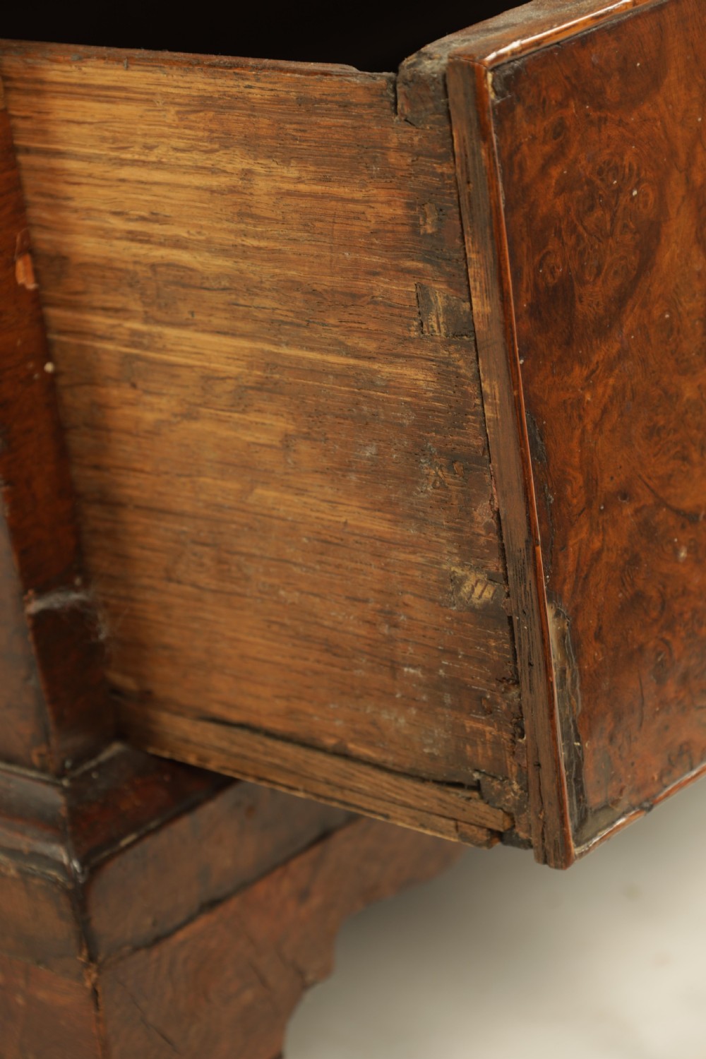 An 18th-century burr walnut bureau featuring a slant-front flap above four graduated drawers with brass handles, resting on bracket feet. View IX