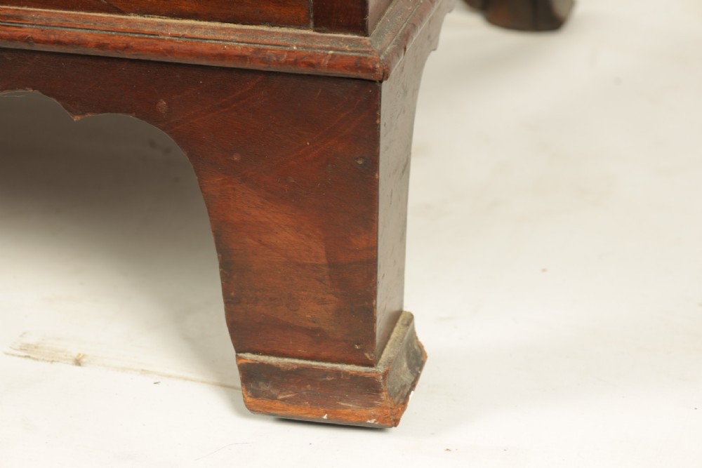 A George III mahogany hanging clothes press featuring two flame mahogany panelled doors over four drawers with brass handles, raised on bracket feet. View VI
