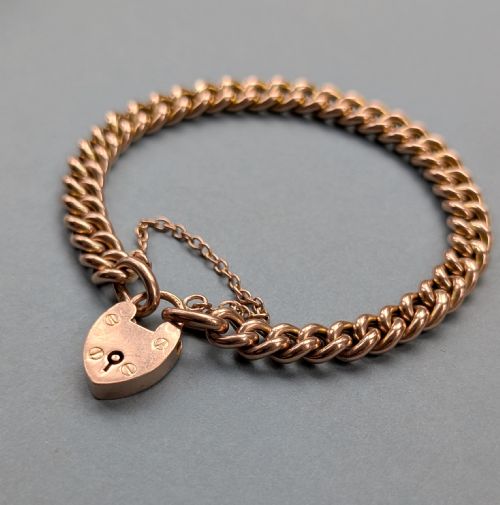 fig 2. An antique 9ct rose gold curb chain bracelet featuring a heart-shaped padlock clasp and an attached safety chain.