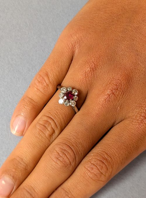 fig 1. An Art Deco platinum ring featuring a circular central red ruby surrounded by a cluster halo of eight round diamonds.