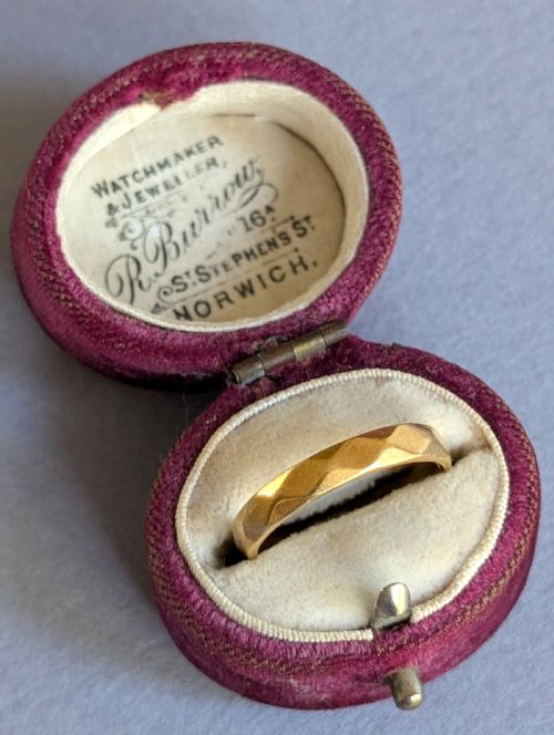 fig 1. A vintage 18ct yellow gold wedding band featuring a faceted geometric pattern around the exterior surface.