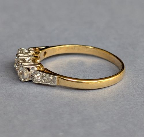 fig 2. An 18ct yellow gold Art Deco ring featuring three round diamonds set horizontally with platinum-mounted diamond accents on the shoulders.