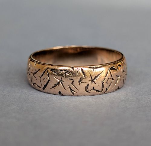 fig 1. An antique 9ct rose gold wedding band featuring hand-engraved star motifs around the exterior circumference.