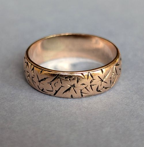 fig 2. An antique 9ct rose gold wedding band featuring hand-engraved star motifs around the exterior circumference.