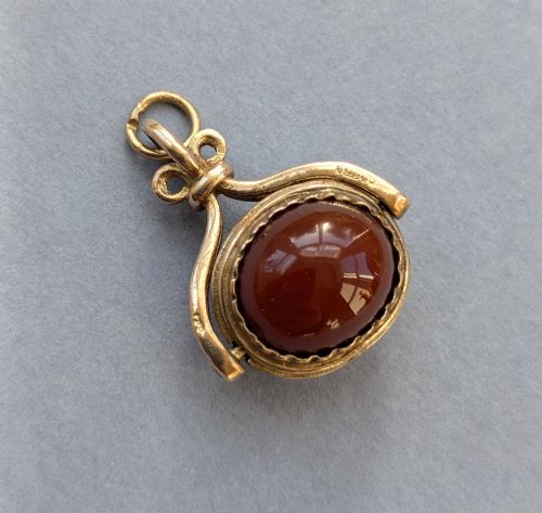 fig 1. An antique 9ct yellow gold spinning fob pendant set with an oval carnelian cabochon within a swivel mount.