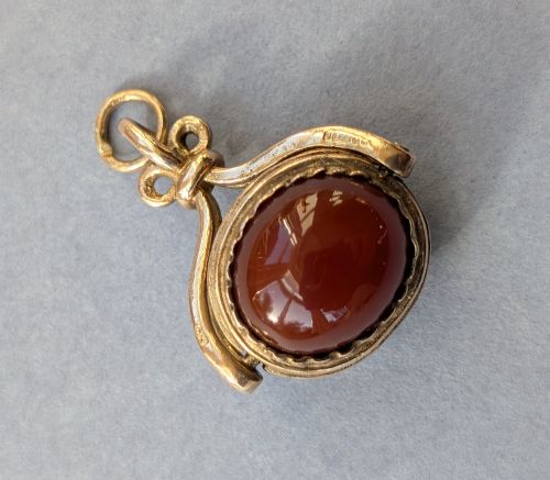 fig 2. An antique 9ct yellow gold spinning fob pendant set with an oval carnelian cabochon within a swivel mount.