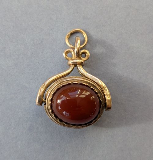 fig 3. An antique 9ct yellow gold spinning fob pendant set with an oval carnelian cabochon within a swivel mount.