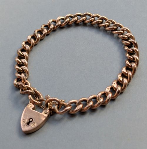 fig 2. An Edwardian 9ct rose gold curb link chain bracelet featuring a heart-shaped padlock clasp and safety chain.