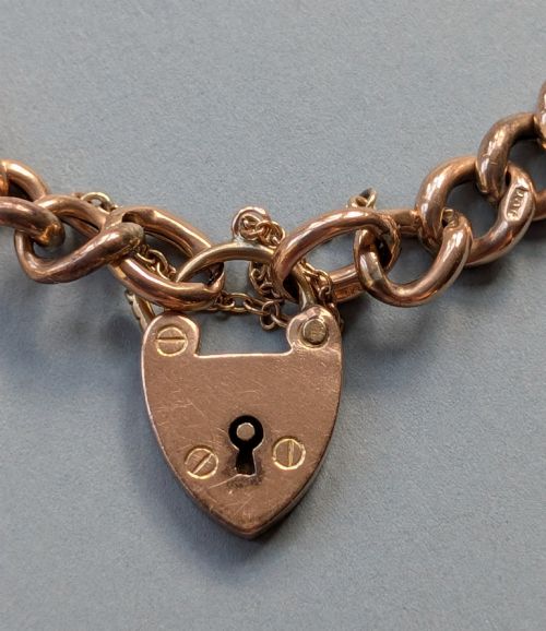 fig 3. An Edwardian 9ct rose gold curb link chain bracelet featuring a heart-shaped padlock clasp and safety chain.