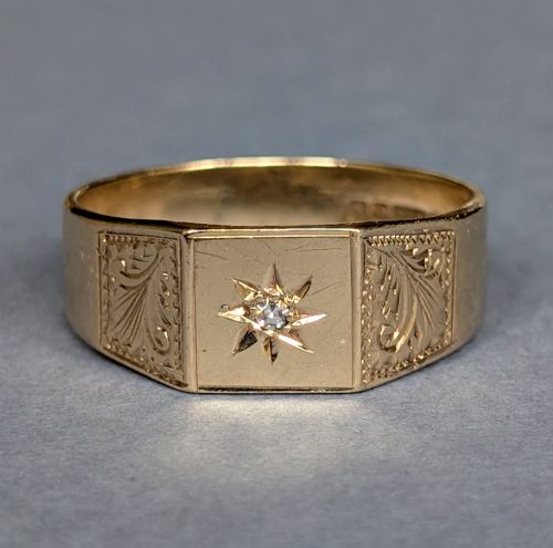 fig 1. A vintage 9ct yellow gold gents signet ring featuring a star-set central stone and foliate engraved shoulders.