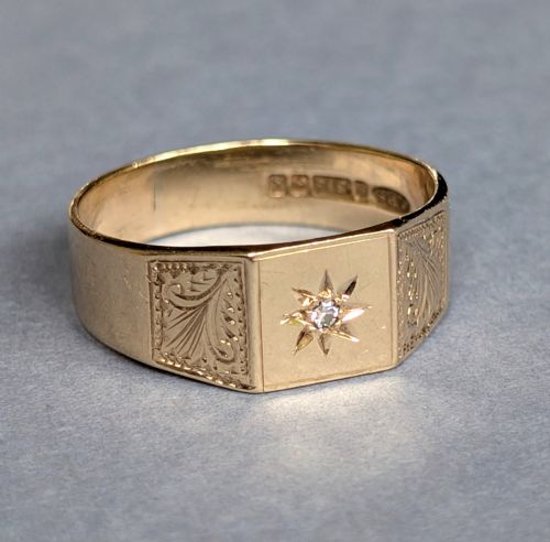 fig 2. A vintage 9ct yellow gold gents signet ring featuring a star-set central stone and foliate engraved shoulders.