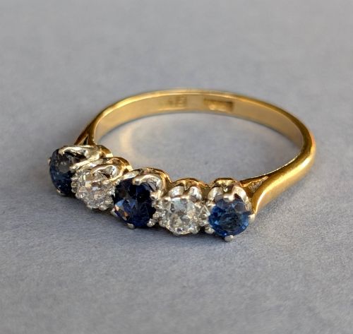 fig 2. An Art Deco five-stone ring featuring three round blue sapphires alternating with two diamonds set in platinum on an 18ct yellow gold band.