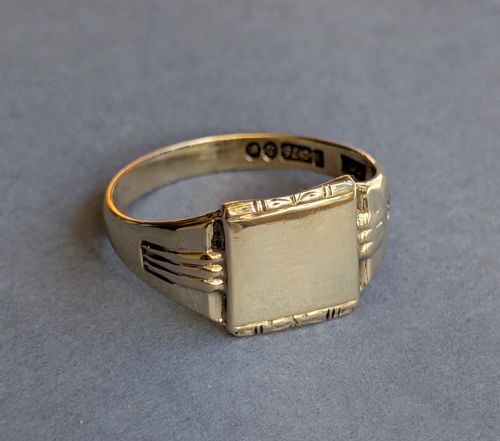 fig 1. A vintage 9ct yellow gold signet ring featuring a flat square face with decorative engraved top and bottom edges and grooved shoulders.