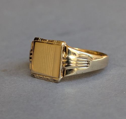 fig 3. A vintage 9ct yellow gold signet ring featuring a flat square face with decorative engraved top and bottom edges and grooved shoulders.