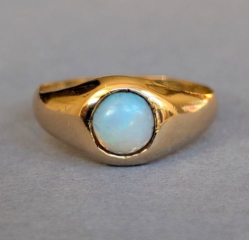 fig 1. An antique yellow gold gypsy ring featuring a central round cabochon opal with blue and orange play-of-colour.