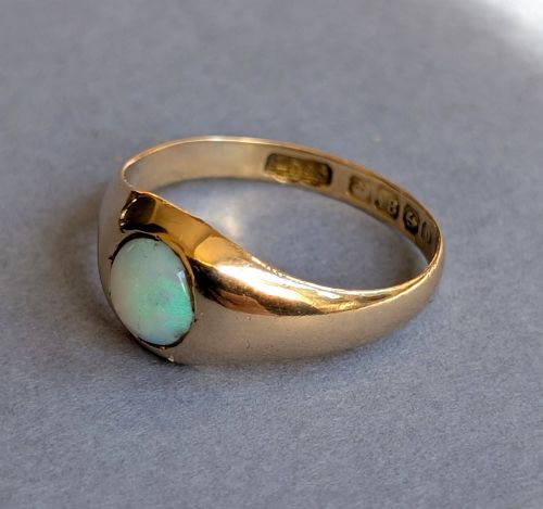 fig 3. An antique yellow gold gypsy ring featuring a central round cabochon opal with blue and orange play-of-colour.