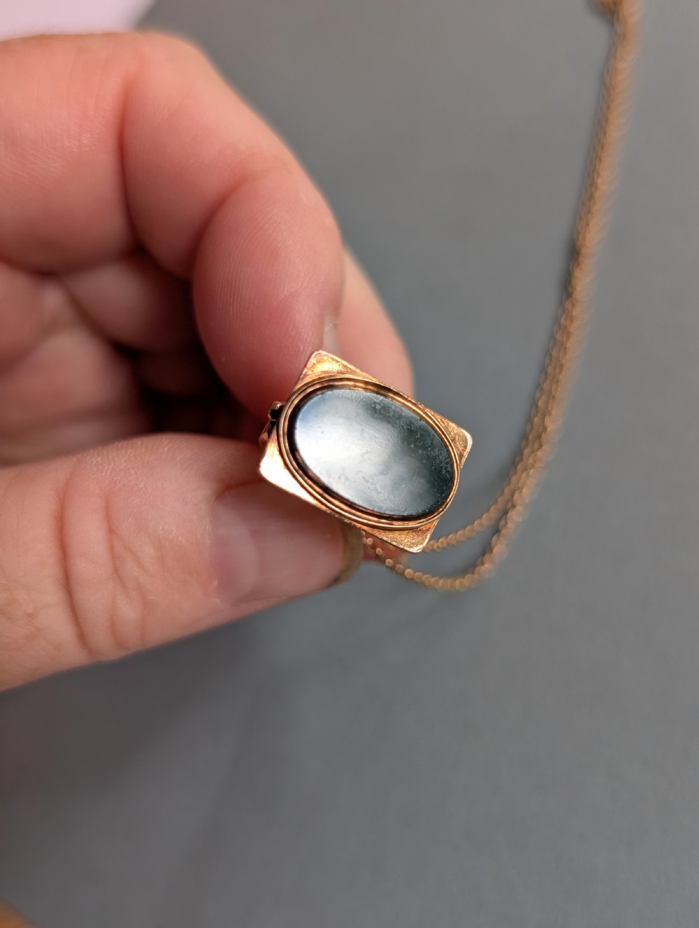 An Edwardian 9ct gold watch fob featuring an arched cage superstructure, geometric chased detailing around the frame, and a dark green bloodstone seal base. View VIII
