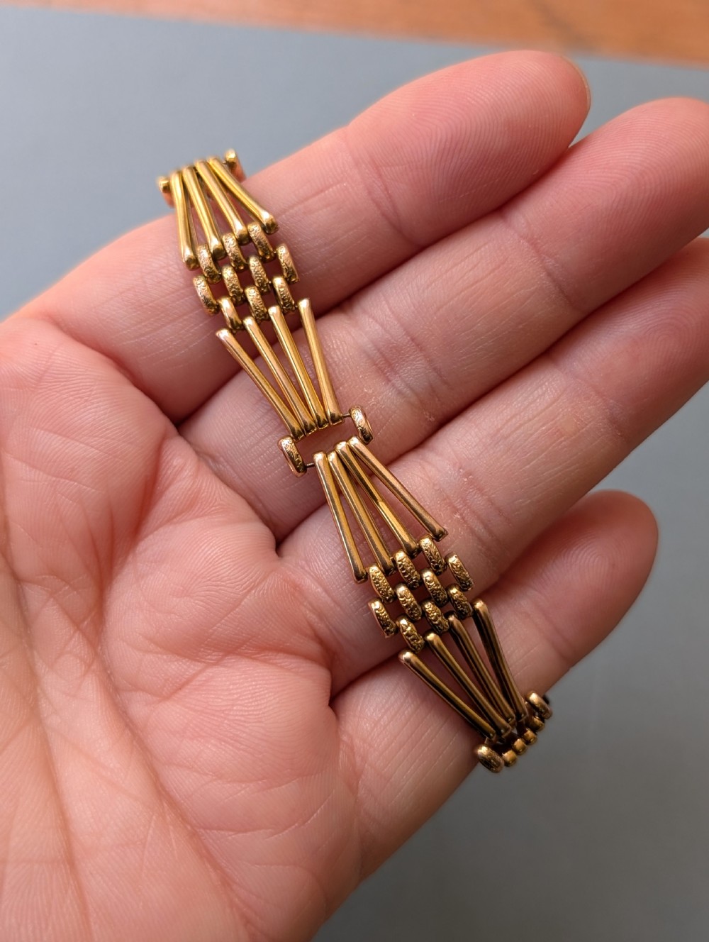 An antique 9ct yellow gold gate link bracelet featuring textured link accents, a safety chain, and a heart-shaped padlock clasp. View X