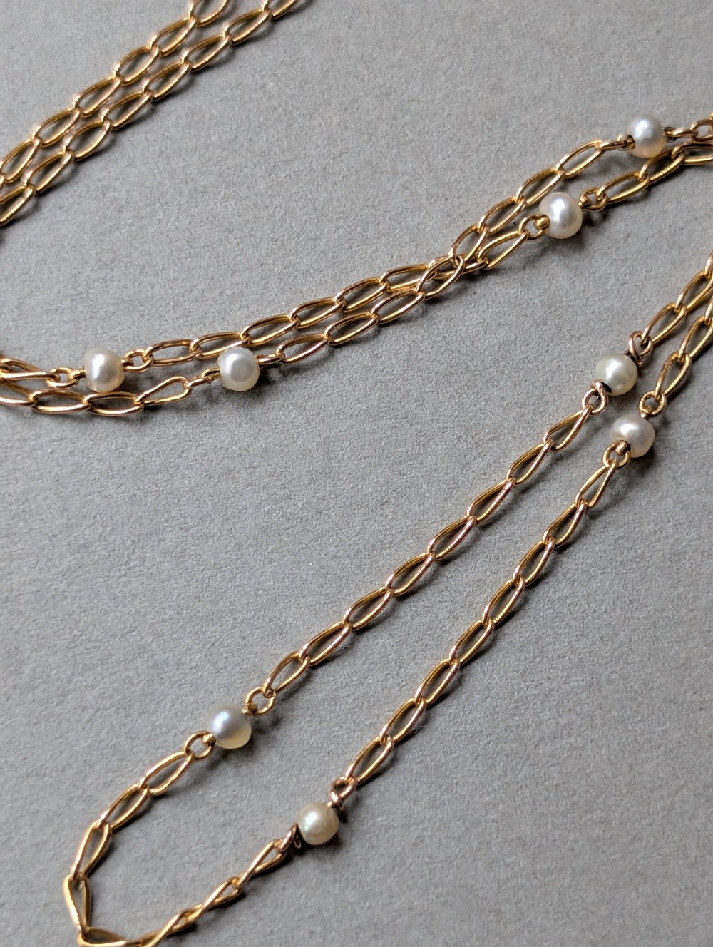 A fine 9ct yellow gold link chain accented with small round pearls placed at spaced intervals. View III