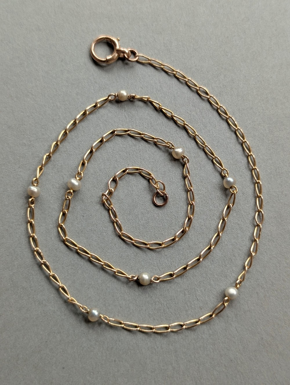 A fine 9ct yellow gold link chain accented with small round pearls placed at spaced intervals. View VII