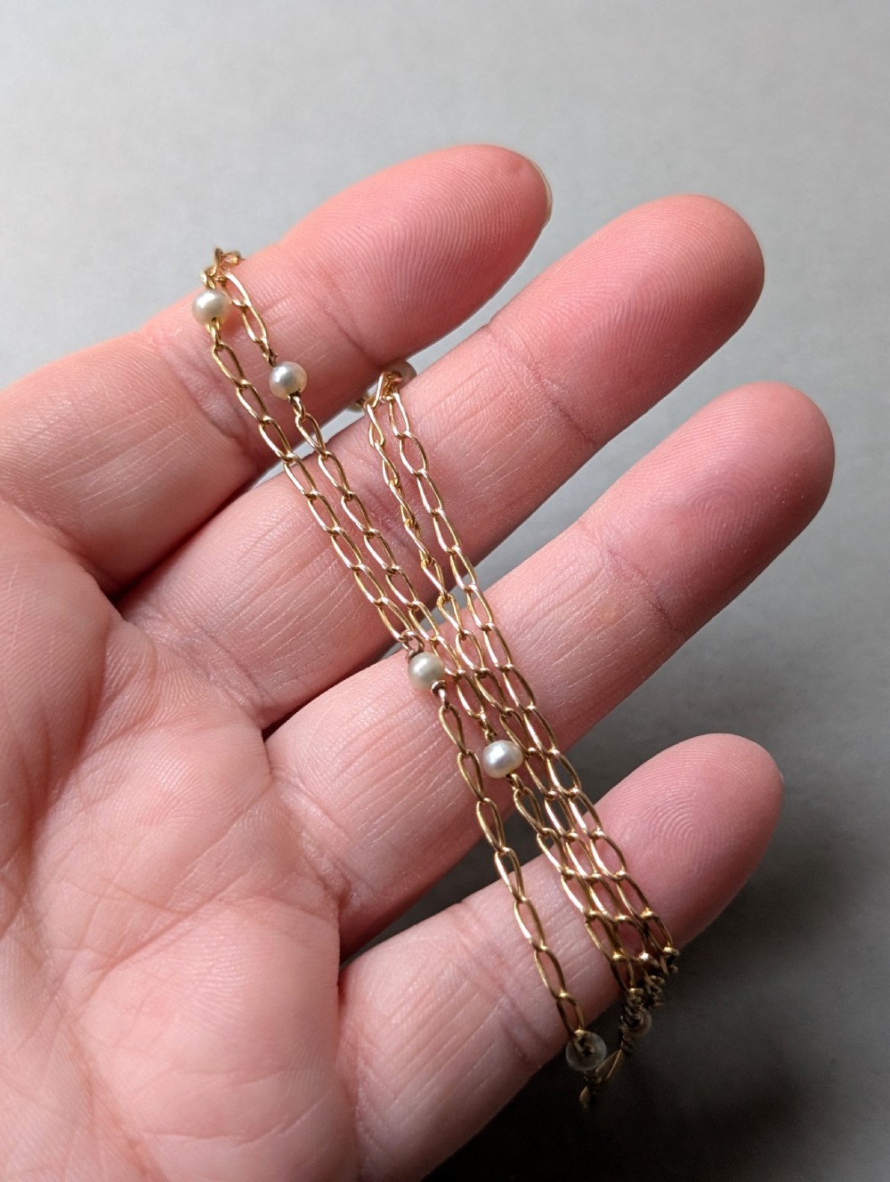 A fine 9ct yellow gold link chain accented with small round pearls placed at spaced intervals. View VIII