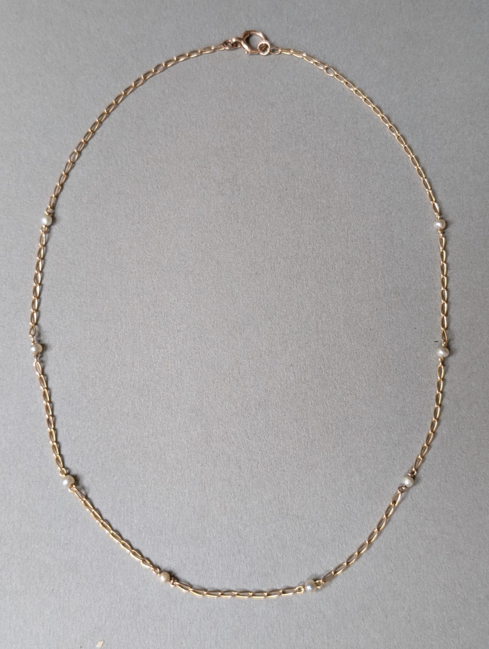 A fine 9ct yellow gold link chain accented with small round pearls placed at spaced intervals. View IV