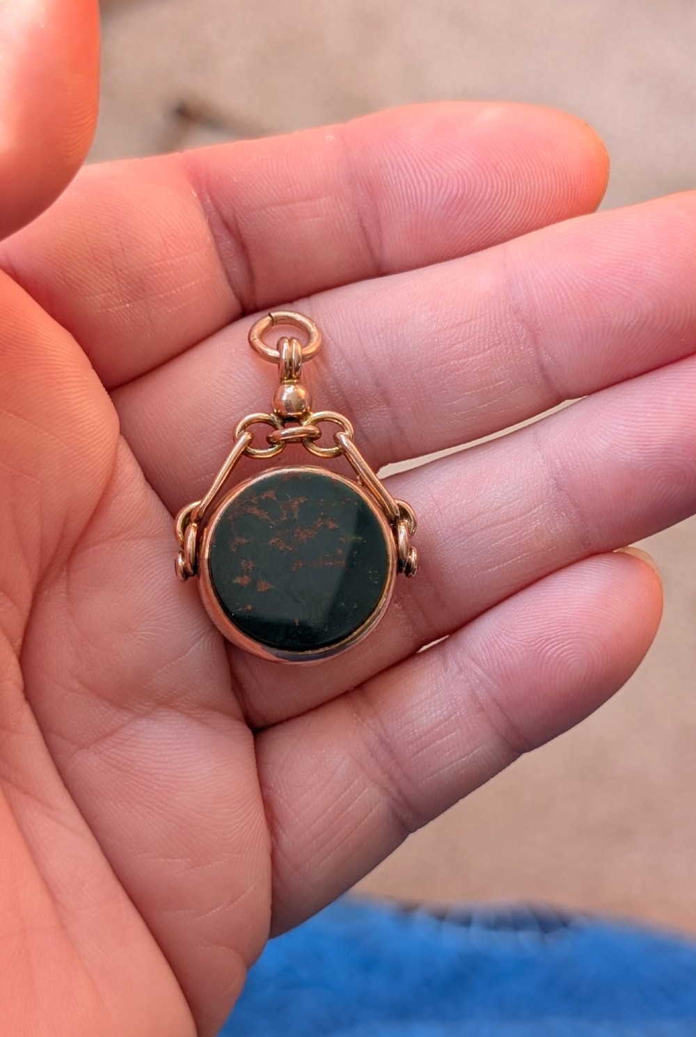 An Edwardian 9ct gold spinning fob pendant set with a polished circular dark green bloodstone gemstone with red flecks. View VII