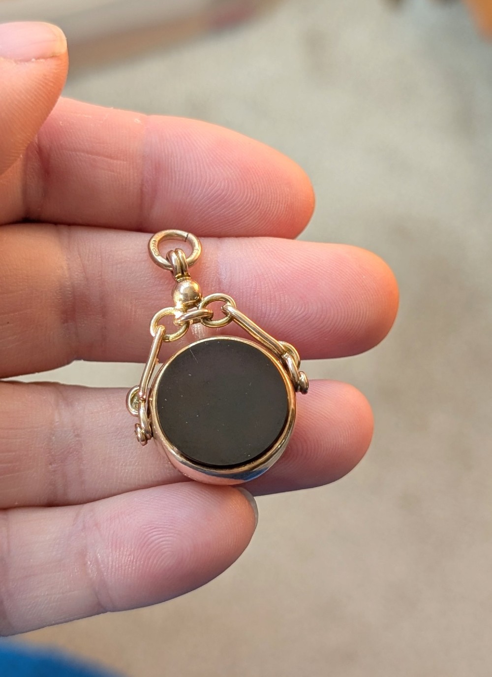An Edwardian 9ct gold spinning fob pendant set with a polished circular dark green bloodstone gemstone with red flecks. View VIII