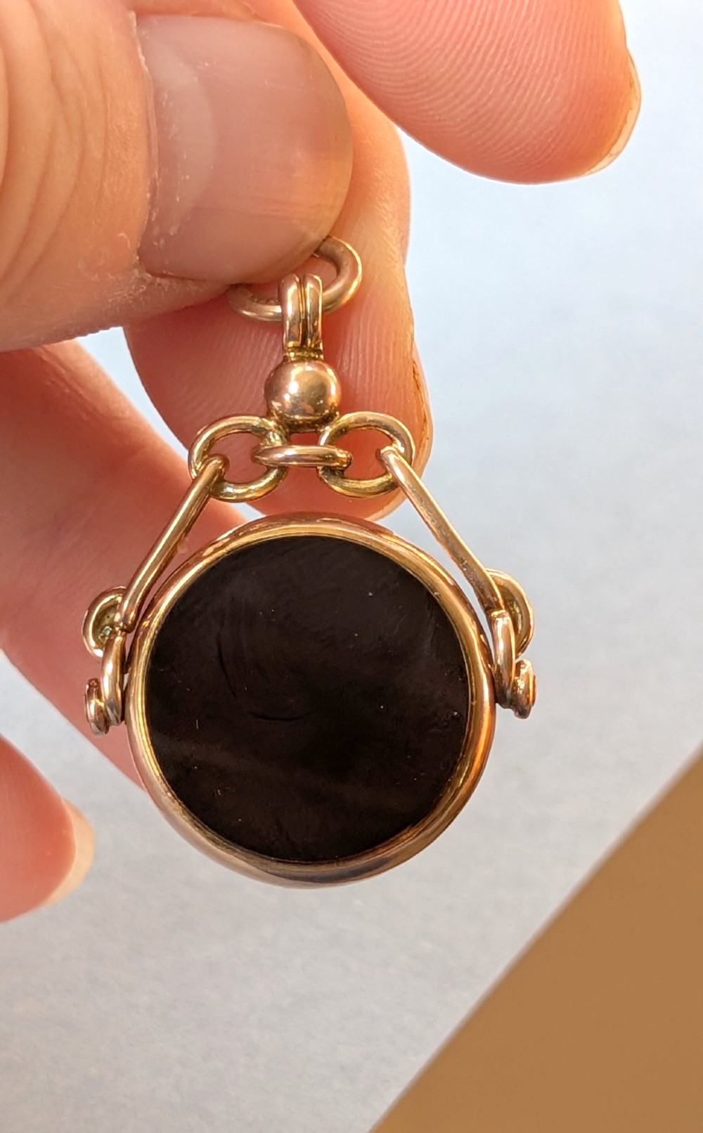 An Edwardian 9ct gold spinning fob pendant set with a polished circular dark green bloodstone gemstone with red flecks. View XI