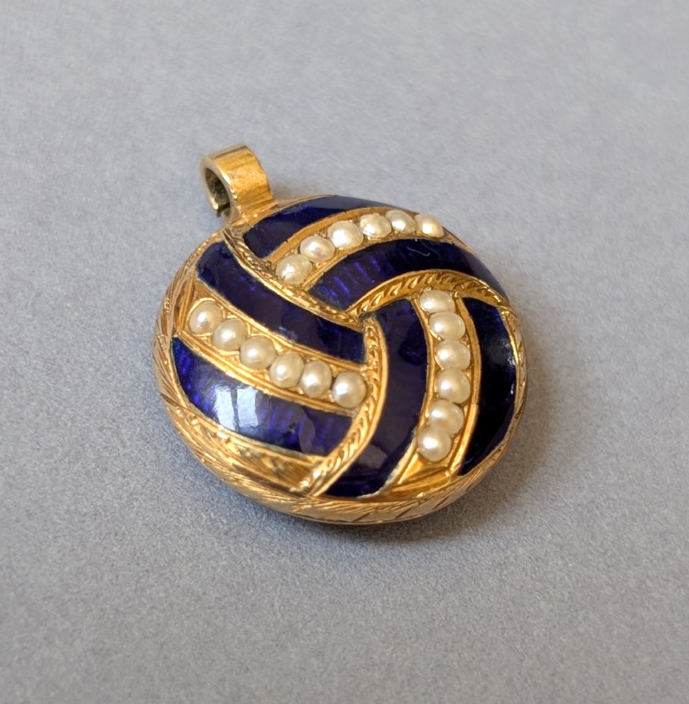 A circular Victorian gold pendant featuring spiralling bands of cobalt blue enamel and set split pearls. View II
