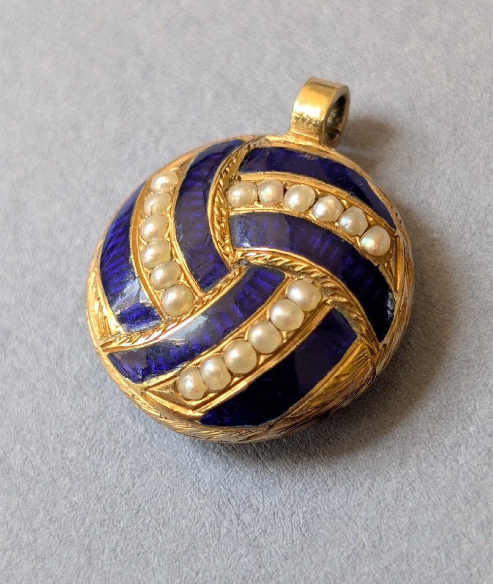 A circular Victorian gold pendant featuring spiralling bands of cobalt blue enamel and set split pearls. View VIII
