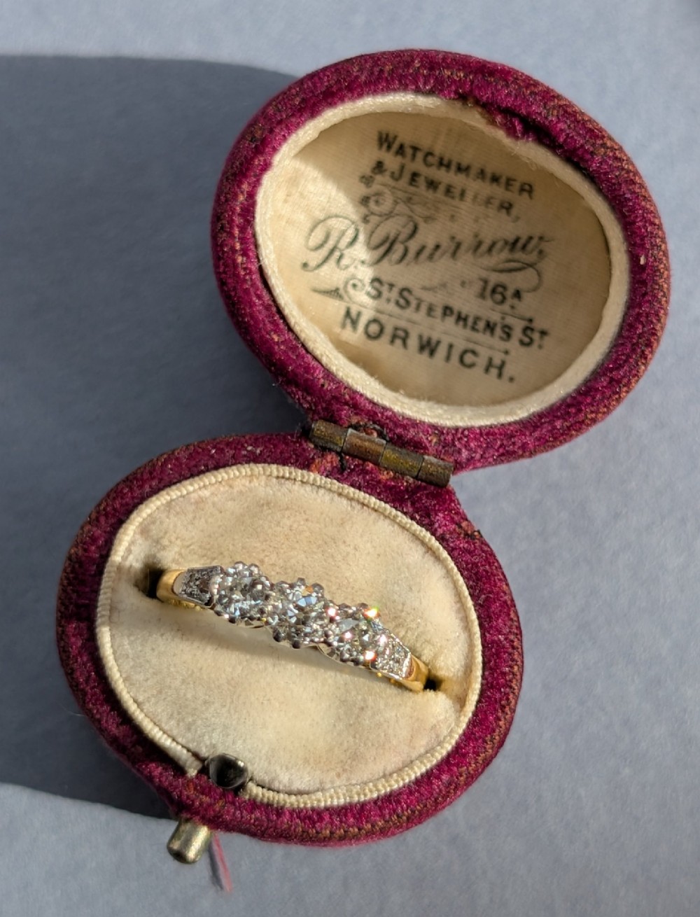 An 18ct yellow gold Art Deco ring featuring three round diamonds set horizontally with platinum-mounted diamond accents on the shoulders. View VIII
