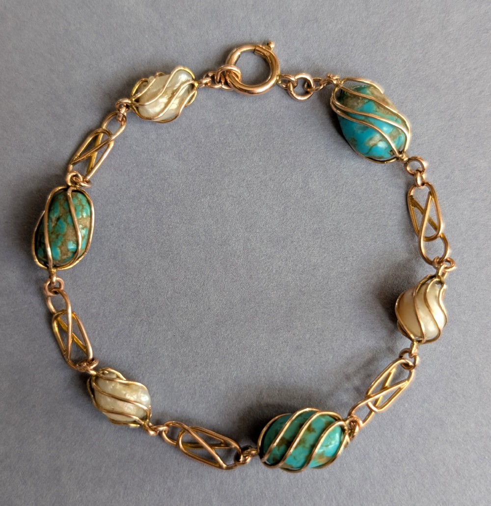 An antique 9ct rose gold bracelet featuring alternating wire-caged turquoise and pearl beads connected by openwork links with a bolt ring clasp. View II