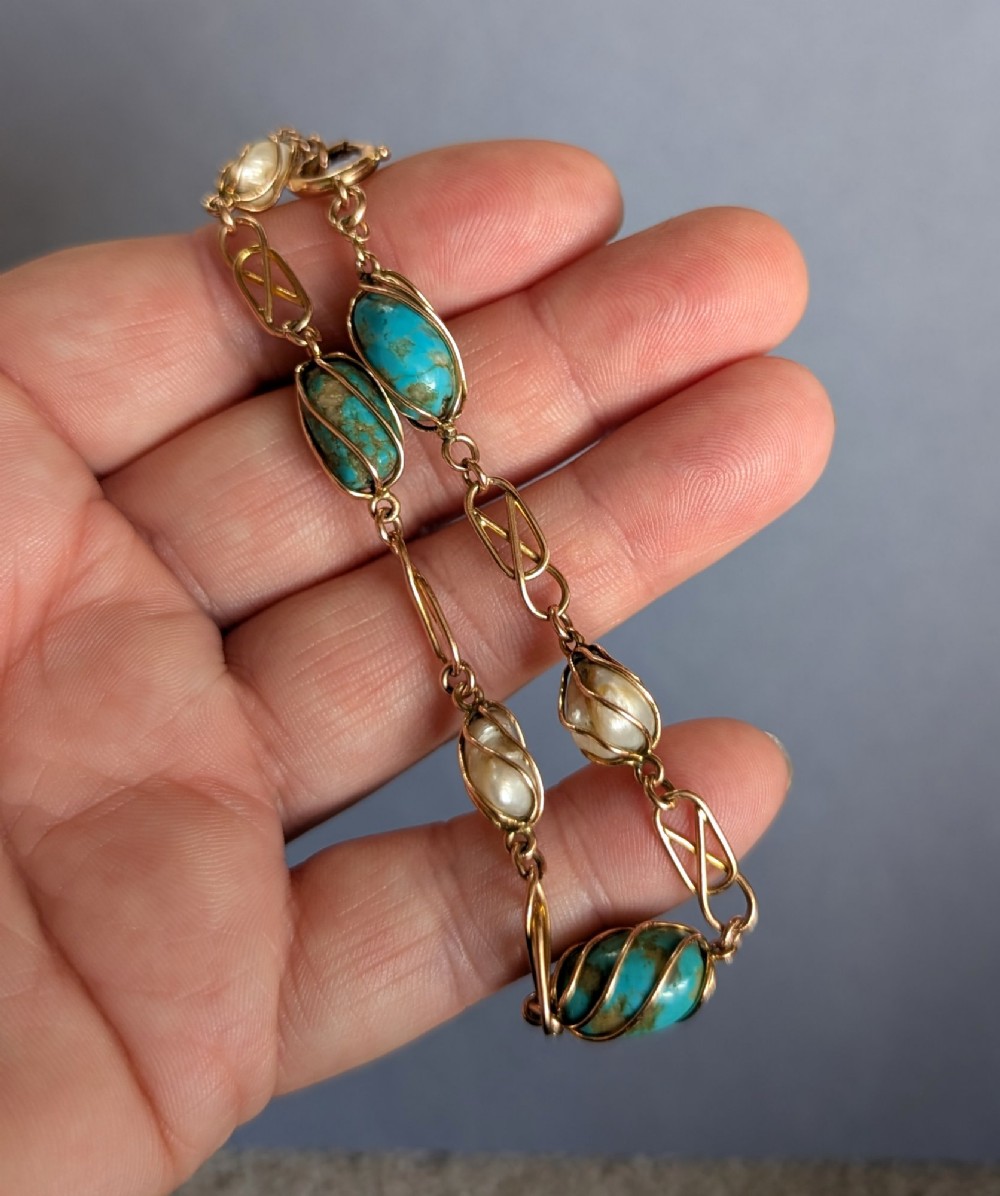 An antique 9ct rose gold bracelet featuring alternating wire-caged turquoise and pearl beads connected by openwork links with a bolt ring clasp. View VI