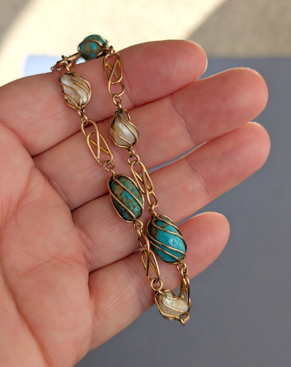 An antique 9ct rose gold bracelet featuring alternating wire-caged turquoise and pearl beads connected by openwork links with a bolt ring clasp. View XI